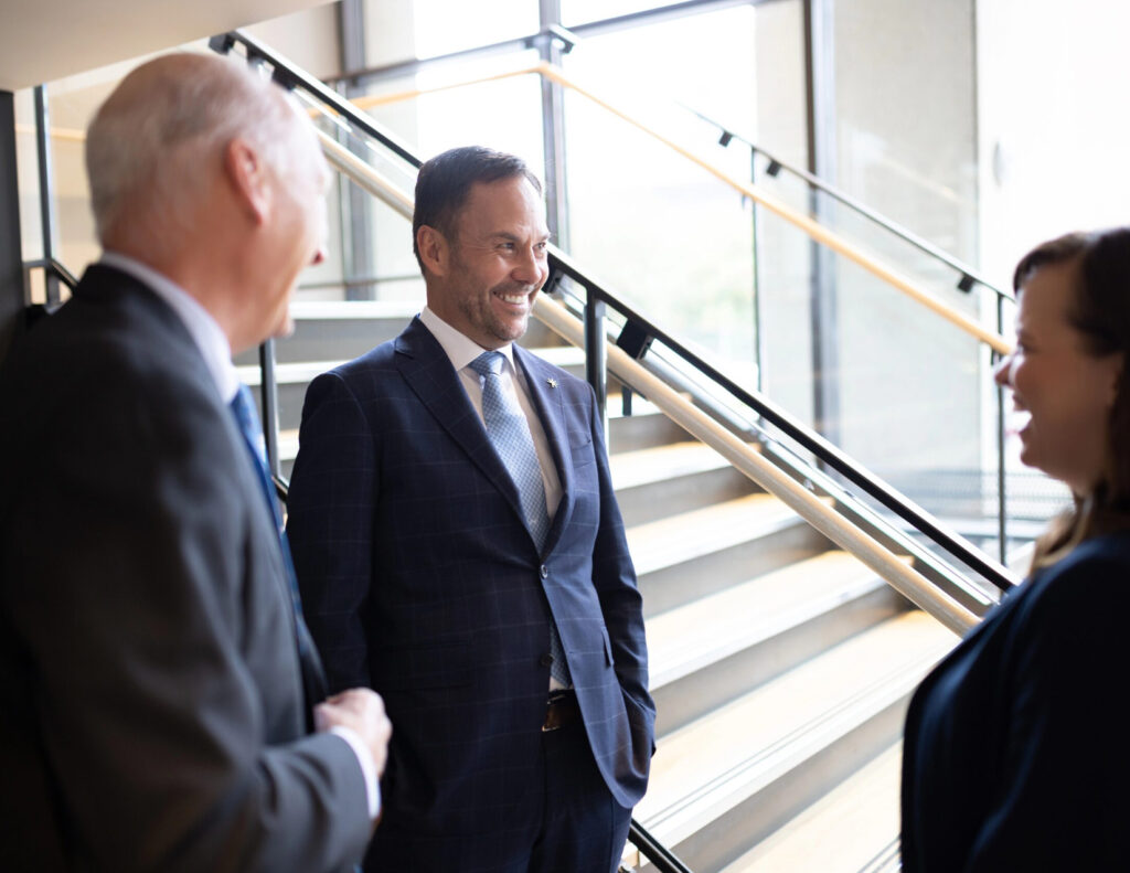 Bright Wire Leadership consultants engaged in a professional conversation near a modern staircase, discussing executive advisory and strategy consulting.